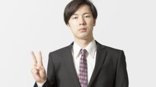 真顔でピースサインをする男性