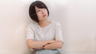 腕組みして考え事をする女性