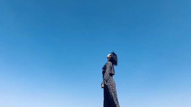 空を向いて歩く女性