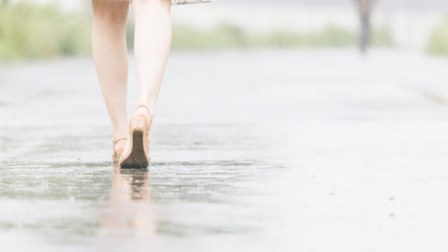彼と別れて雨の中を歩く女性